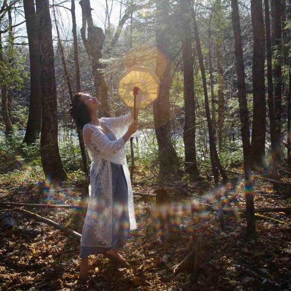 Sao Aum avec un tambour chamanique dans les airs qui se promène dans la forêt.